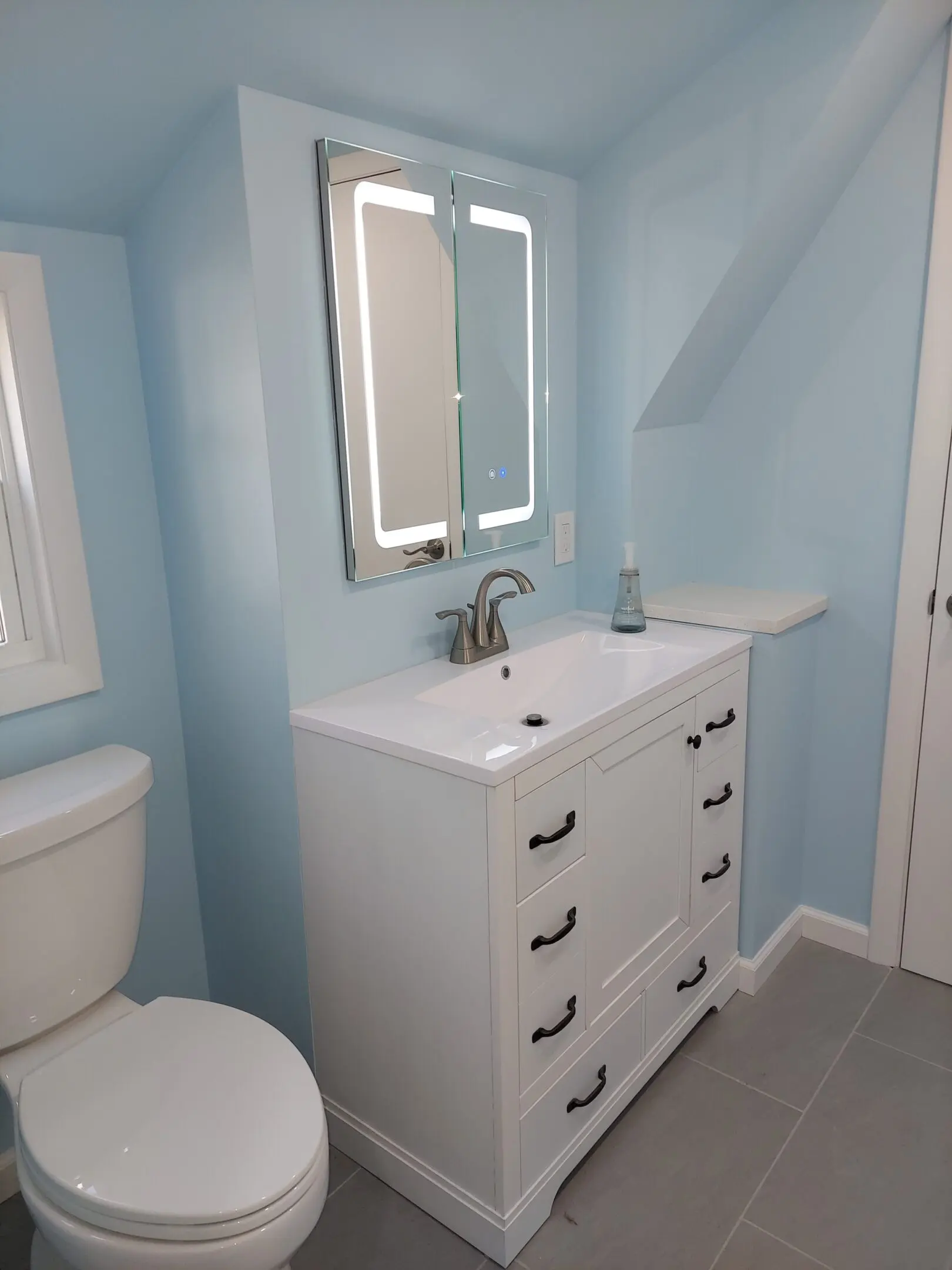 Modern bathroom with blue walls and sink.
