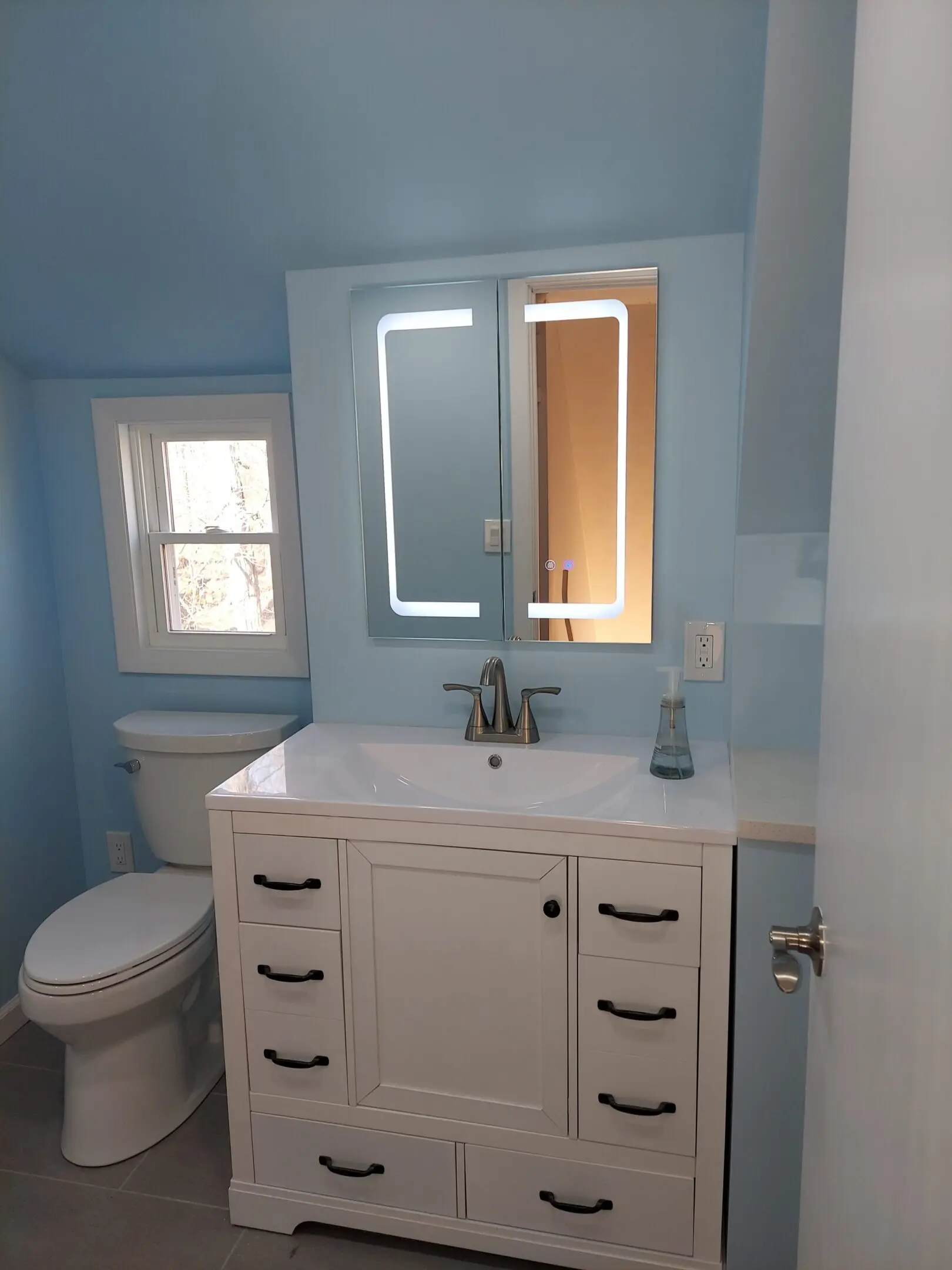 Small bathroom with modern vanity and mirror.