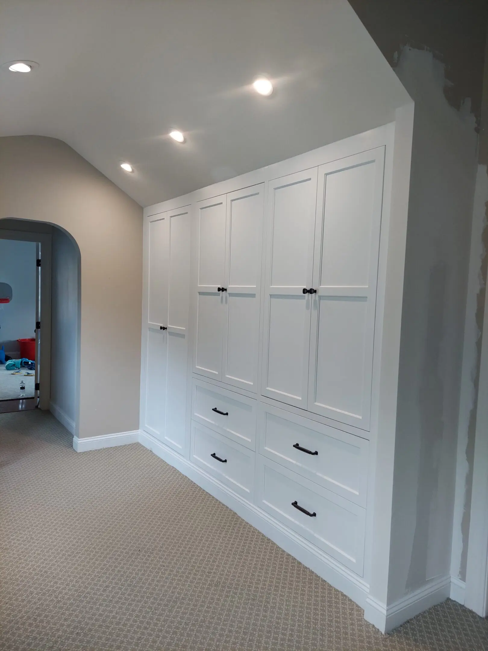 Built-in white cabinets with overhead lights.
